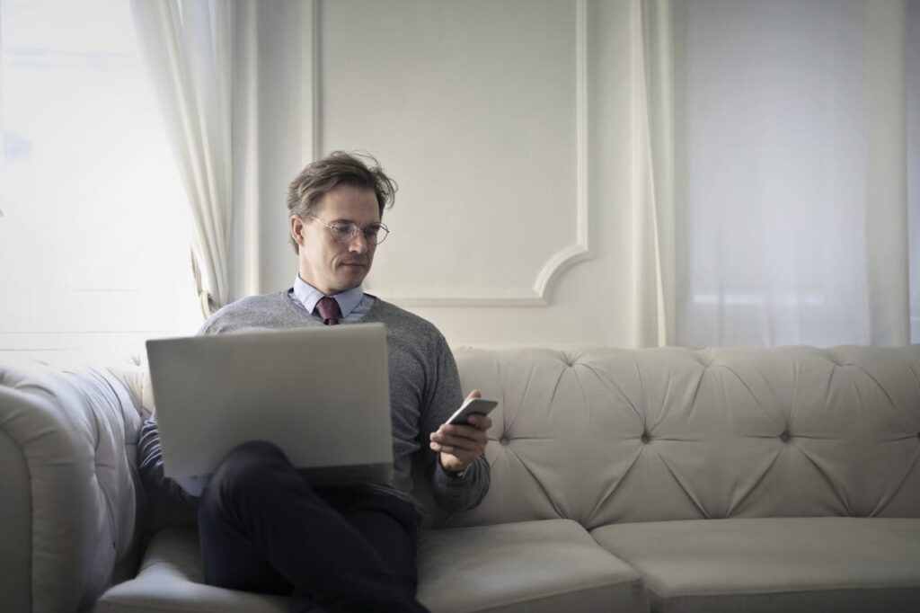 Man on couch accessing laptop with multi-factor authentication