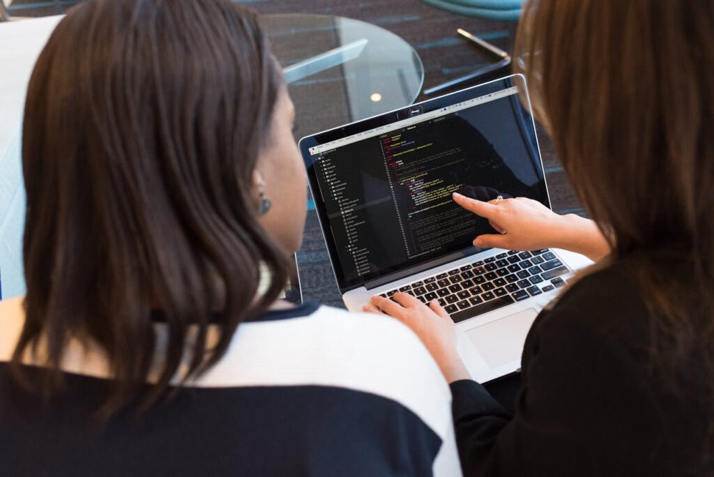Women looking at a laptop using DevOps for financial services