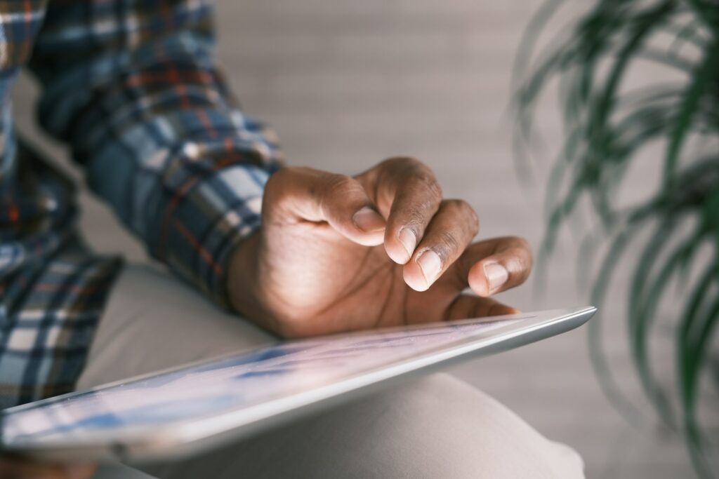 man's hand scrolling through SOC report on a tablet