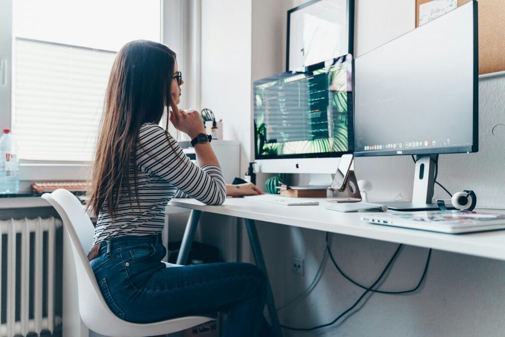 women sitting at a desk working on explainable AI (XAI) code in a bright office