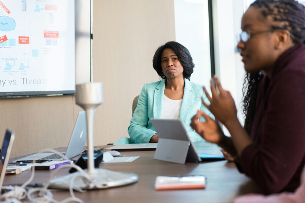 two women discussing autonomous penetration testing ina meeting room