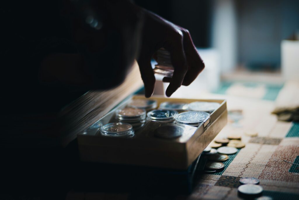 Hand reaching into a box for a coin representing tokenization in finance