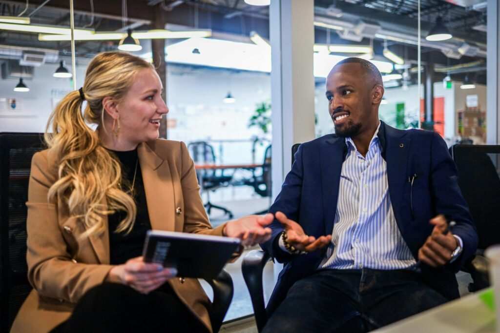 A man and a woman in an open office engaging in proxy voting through a tablet