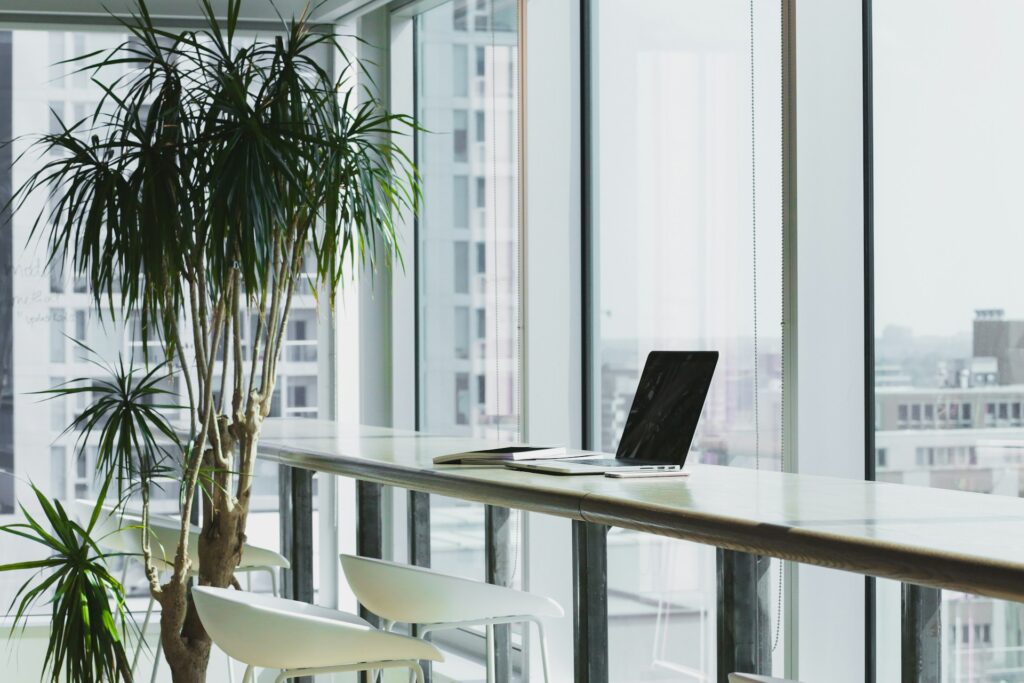 Laptop accessing green cloud infrastructure in glass office