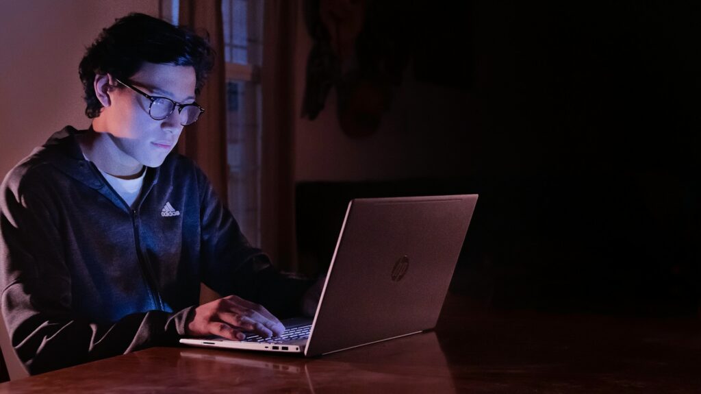 Man working on Web3 on a MacBook in a dark office
