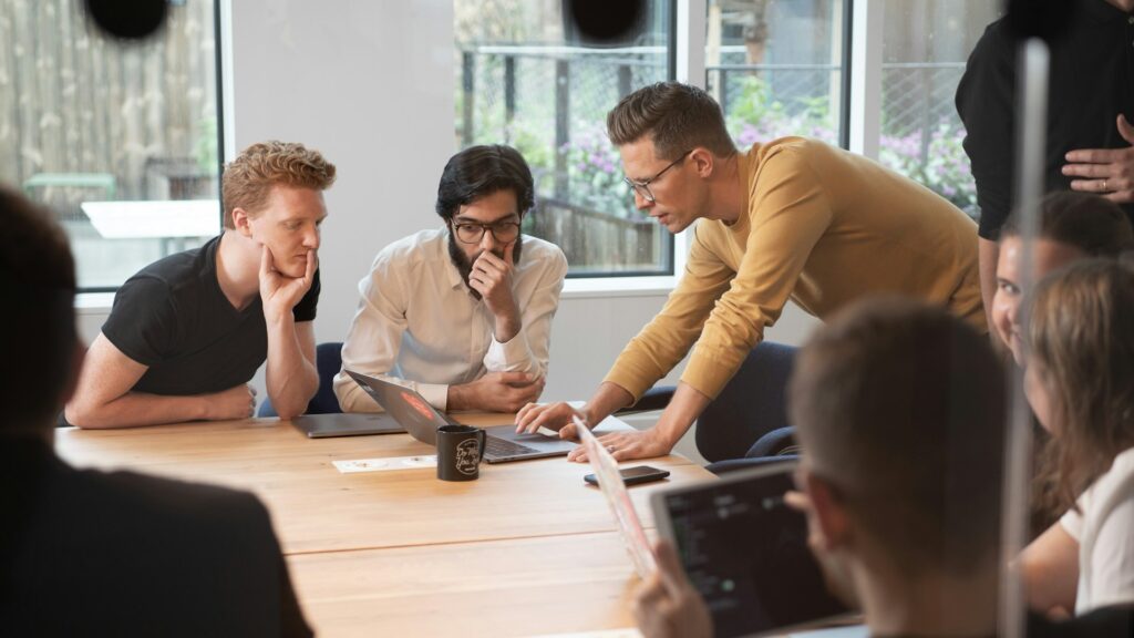 A group of professionals at a conference table while looking at synthetic data sets.