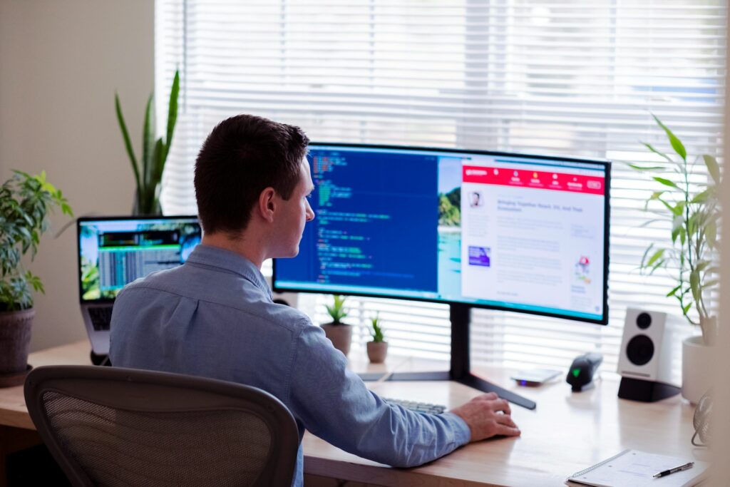 a male office employee uses a desktop computer to access cloud computing in banking.