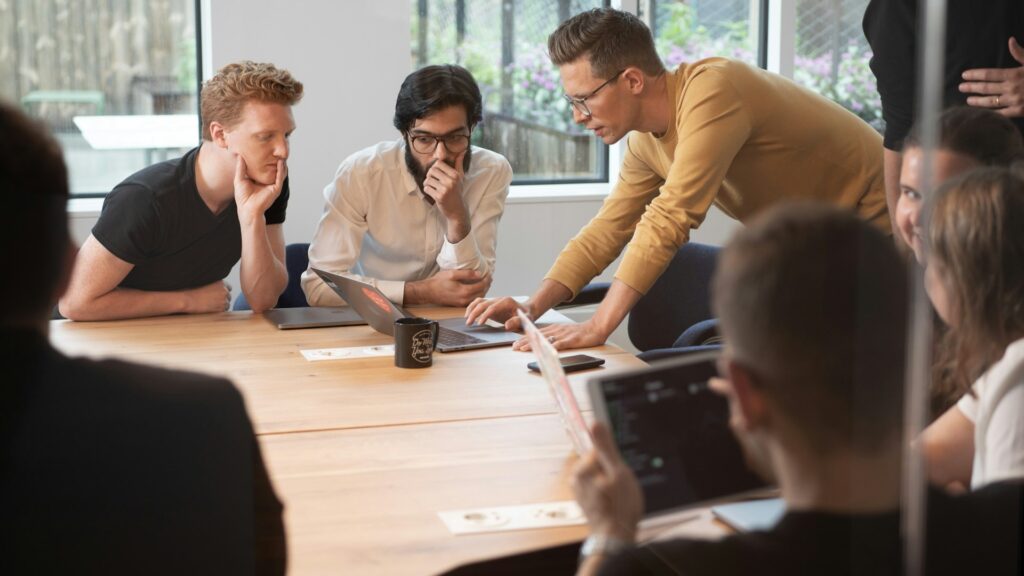 Colleagues work on robotic process automation around a conference table in the back office.