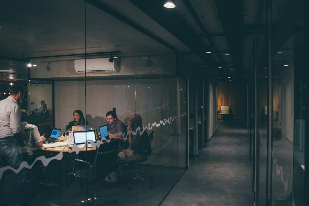 Colleagues have a meeting over intelligent automation in a darkened conference room at night.