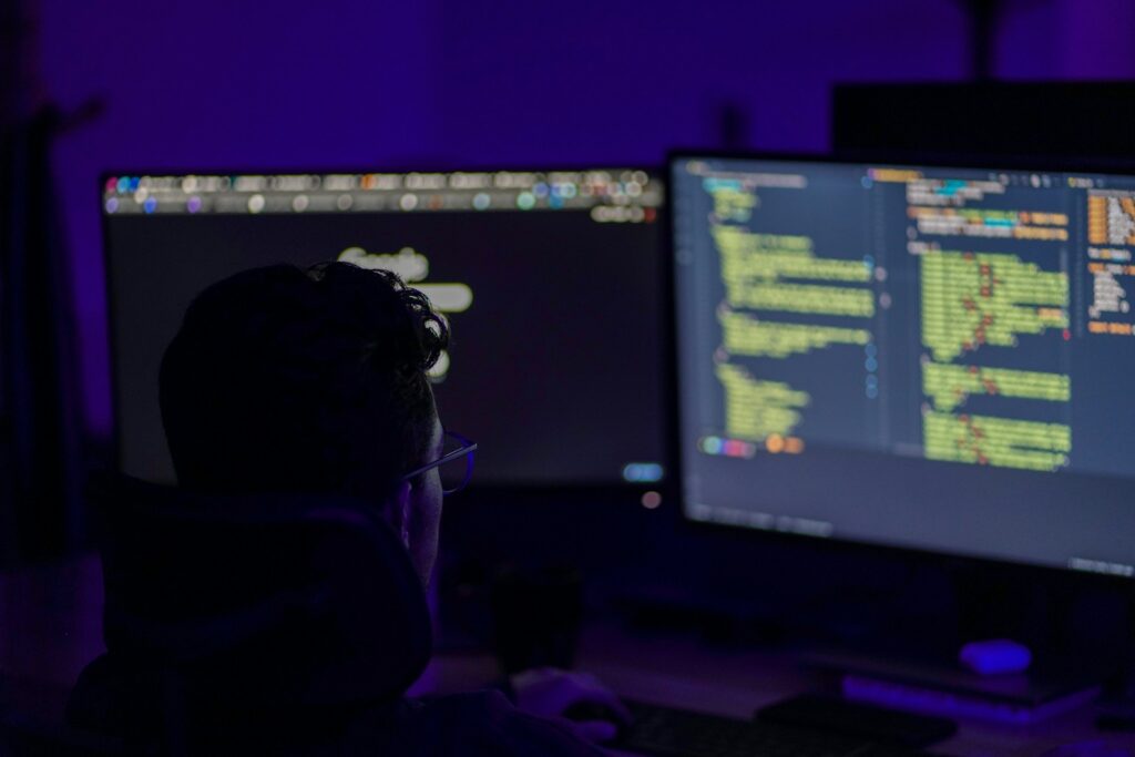 Programmer working on AI cloud security in a dark office.