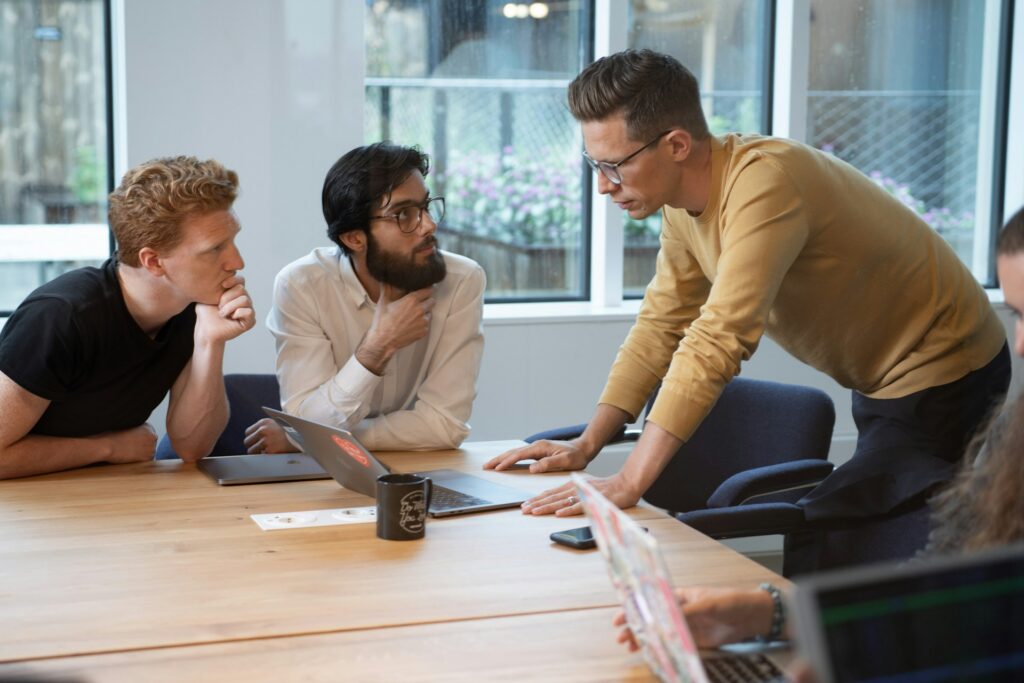 Three colleagues meet at a table and discuss infrastructure visibility.